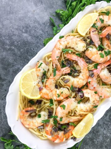 shrimp scampi from Flavor Portal recipe on a bed of noodles on a white platter
