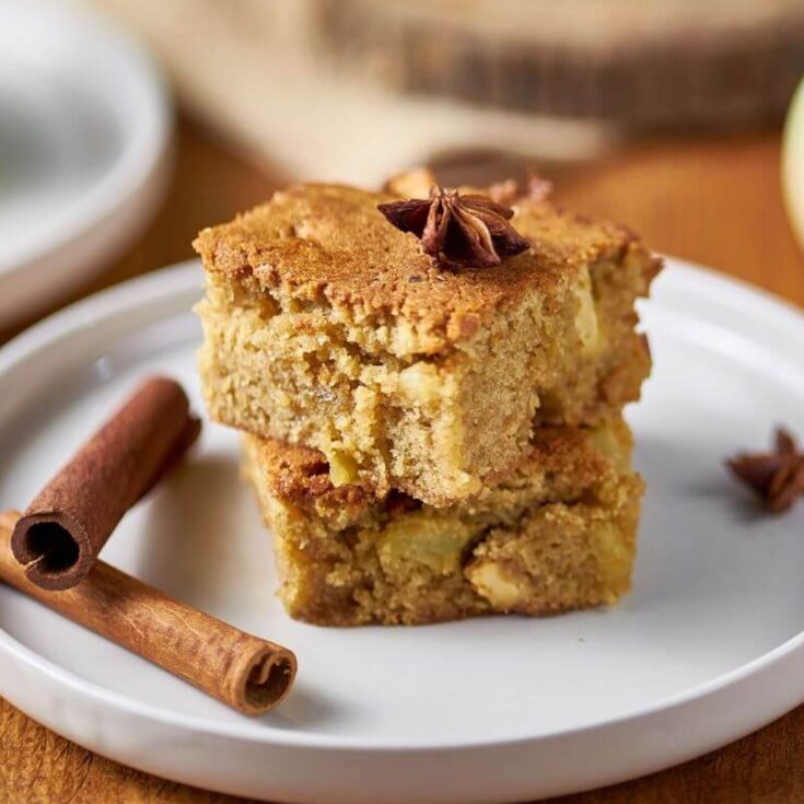 cinnamon apple blondies from Flavor Portal recipe stacked on a plate with cinnamon sticks