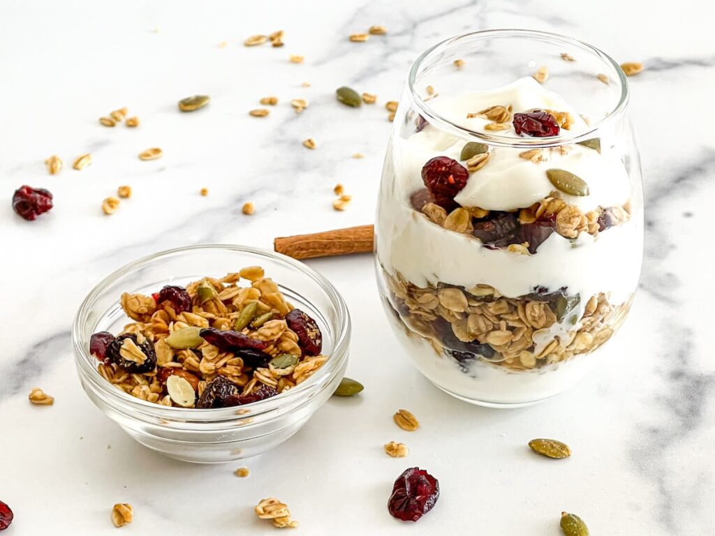 cinnamon granola yogurt parfait from Flavor Portal recipe layered in a glass next to a small bowl of granola