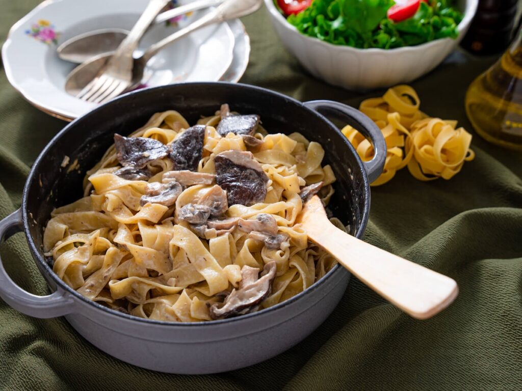 mushroom alfredo from Flavor Portal recipe with in a pot next to salad