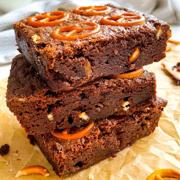 stack of three salted pretzel brownies from Flavor Portal recipe on parchment paper