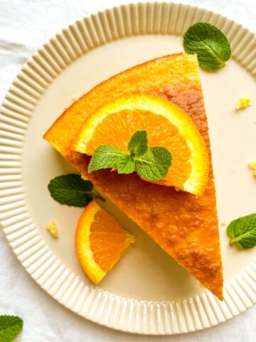 slice of orange lemon yogurt cake from Flavor Portal recipe garnished with mint leaves on a plate